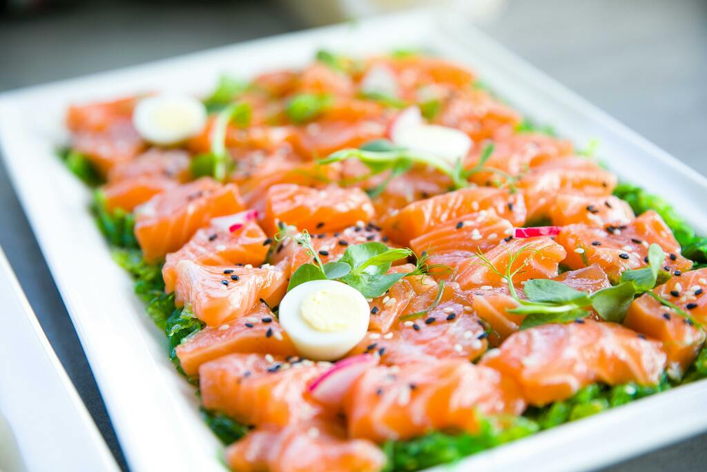(keto recipes) a white plate topped with lots of salmon on top of lettuce